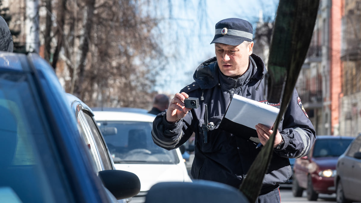 Водитель эвакуатора общается с клиентом возле погруженной на платформу машины на ночной трассе